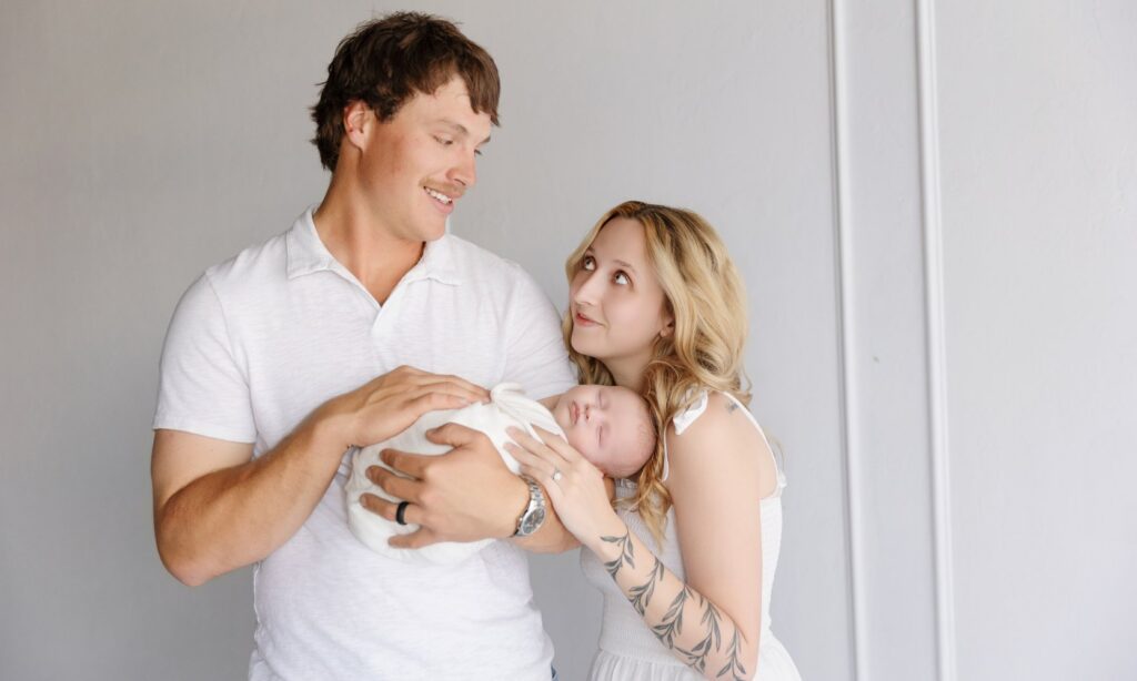 Family looking through printed newborn photos together at home